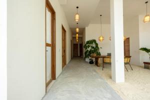 ein Flur mit weißen Wänden und Pendelleuchten in der Unterkunft Odi Beachfront Kamadhoo in Kamadhoo + 15 Fotos