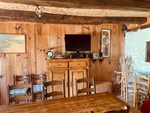 a living room with a television and a table and chairs at La Ruche - Coquelicot in Mauriac