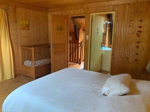 a large white bed in a room with wooden walls at Gîte La Ruche in Mauriac