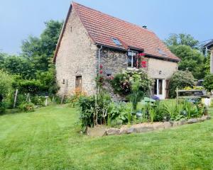 a stone house with a garden in front of it at Gîte La Ruche in Mauriac