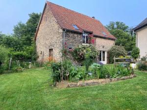 an old stone house with a garden in front of it at La Ruche - Tournesol in Mauriac