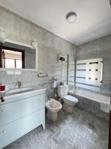 a bathroom with a sink and a toilet and a tub at Casa Pichi in El Pulliu