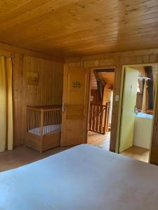 a bedroom with a bed in a room with wooden walls at La Ruche - Tournesol in Mauriac