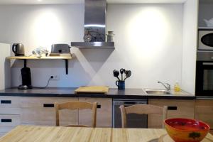 a kitchen with a table and chairs and a sink at Apartment with a large tree-lined terrace in Sanary-sur-Mer