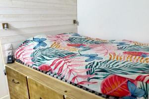 a bed with a colorful comforter on top of it at Apartment with a large tree-lined terrace in Sanary-sur-Mer