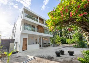 ein weißes Haus mit vielen Fenstern in der Unterkunft Odi Beachfront Kamadhoo in Kamadhoo