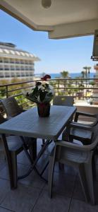 a table with a vase of flowers on a balcony at Palmen Apart Hotel in Alanya