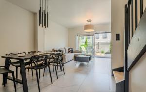 a dining room with a table and chairs and a couch at Słoneczne Tarasy in Rewal