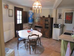 a kitchen and dining room with a table and chairs at Lou Mazet - Entre Vignes et Garrigue in Valflaunès