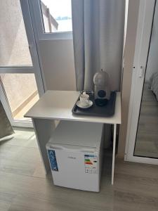 a small white table with a tea kettle on it at La Cer in Constanţa