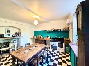 a kitchen with a wooden table and a stove at Chambre 2 personnes Maison Saint Jean in Château-Chalon