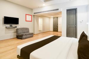 a bedroom with a large bed and a television at Super Townhouse Gomti Nagar Matiyari in Lucknow