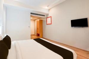 a bedroom with a bed and a flat screen tv at Super Townhouse Gomti Nagar Matiyari in Lucknow +30 photos
