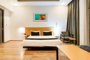 a hotel room with a large bed and a table at Super Townhouse Gomti Nagar Matiyari in Lucknow