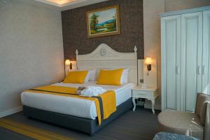 a hotel room with a large bed with yellow pillows at Resun Hotel in Ankara +68 photos