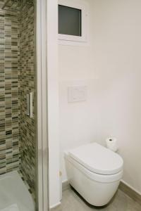 a white bathroom with a toilet and a shower at Hotel Rosamar - Emar Hotels in Es Pujols