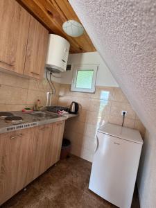 a small kitchen with a sink and a refrigerator at Village Cottage in Žabljak