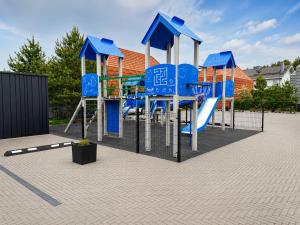 a playground with blue chairs and a slide at Sakalo kopa in Palanga