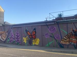 a mural of butterflies and flowers on a wall at The Loft at Design Bank in Milltown Malbay +8 photos