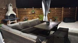 a patio with a couch and a table and a fireplace at Dalmatian Stone House Angela in Drniš