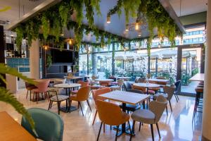 a restaurant with tables and chairs and plants at Travelodge Madrid Arturo Soria in Madrid