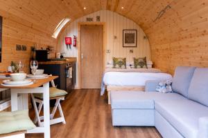 a room with a bed and a couch and a table at Great Hallingbury Lodges in Hallingbury