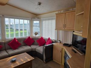 a living room with a couch with red pillows at Julie and Shaun's in Ingoldmells