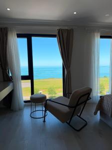 a living room with a chair and a large window at THE DECK OTEL in Trabzon