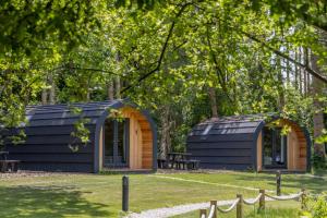 a black building in the middle of a yard at Great Hallingbury Lodges in Hallingbury +7 photos