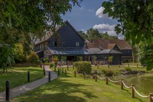 a house with a fence in front of a yard at Great Hallingbury Lodges in Hallingbury