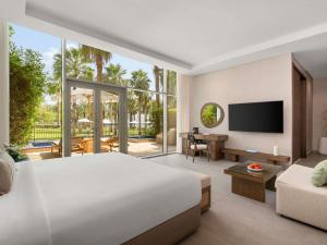 a bedroom with a large bed and a living room at Rixos The Palm Hotel & Suites - Ultra All Inclusive in Dubai