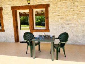a table with two chairs and a table and a window at Chambres de l'Igues in Montfaucon +12 photos