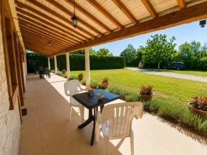a patio with a table and chairs under a wooden pergola at Chambres de l'Igues in Montfaucon