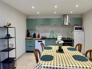 a kitchen with a table and a kitchen with green cabinets at Corps de ferme à 50min de Lyon in Moissieu-sur-Dolon
