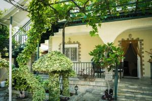 a house with a porch with trees and plants at Galini Cosy Home in Asprovalta