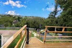 a wooden stairway with a wooden railing and trees at Panorama in Seigy