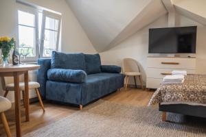 a living room with a blue couch and a tv at Pokoje ABC Centrum in Ustka