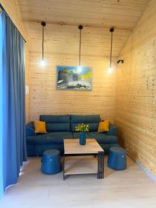 a living room with a blue couch and a table at Cottage Ametapi in Mestia