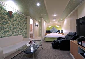a living room with a couch and a bed at HOTEL K's L Adult only in Urigōchō