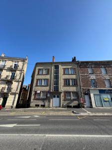 two buildings on a city street with a blue sky at Magnolia in Épernay