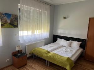 a bedroom with a bed with a green blanket on it at NOVA Motel in Międzyrzecz