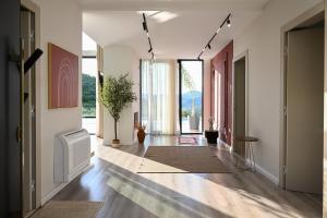 a hallway with white walls and wood floors and large windows at Villa 30 Luxury Place Vlore in Fshati i Ri