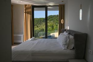 a bedroom with a large bed with a large window at Villa 30 Luxury Place Vlore in Fshati i Ri +119 photos