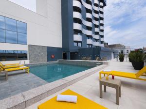 a building with a swimming pool and a building at Novotel Itajai Navegantes in Itajaí