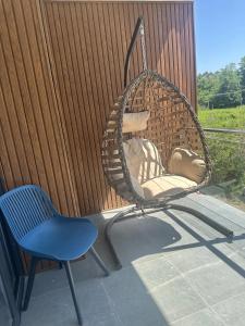a swinging chair and a blue chair on a porch at terrace kaprovan in Urekis Sadguri