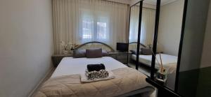 a small bedroom with a bed and a mirror at Galini Cosy Home in Asprovalta