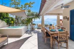 a patio with a table and a bath tub at Casa Mamà private access to sea in Santa Flavia