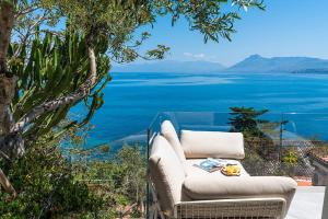 a couch sitting on a balcony with a view of the water at Casa Mamà private access to sea in Santa Flavia