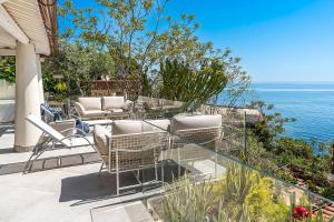 a patio with chairs and a view of the ocean at Casa Mamà private access to sea in Santa Flavia