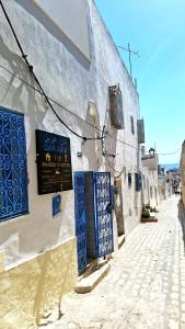 a building with blue and white doors on a street at Dar Aziz VIP in Sousse